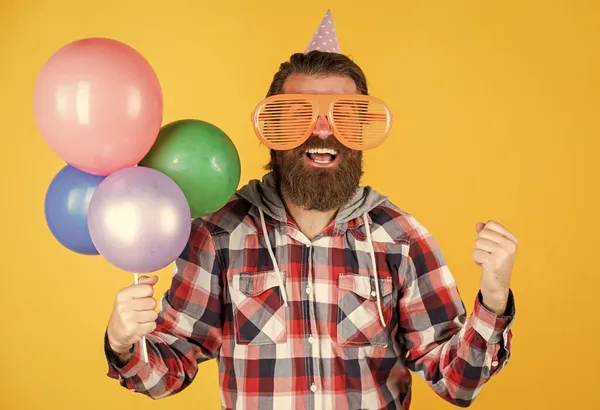 Snygg skäggig kille med trendig frisyr bära rutig skjorta hålla fest ballonger, fest — Stockfoto