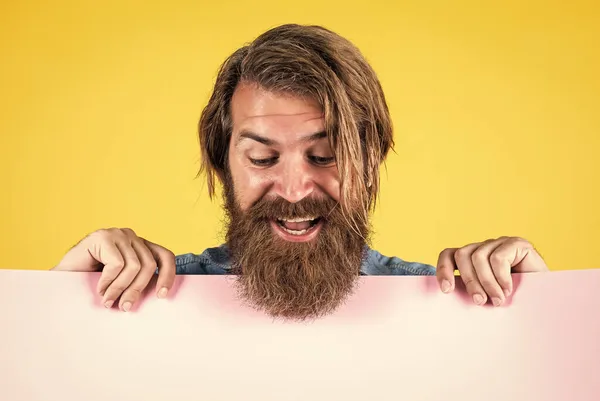 Deixa-me ver. homem barbudo segurando placar. Procurado. papel vazio para sua informação. conceito barbeiro. hipster feliz com barba em folha de papel. lugar vazio para espaço de cópia. precisa de ajuda — Fotografia de Stock