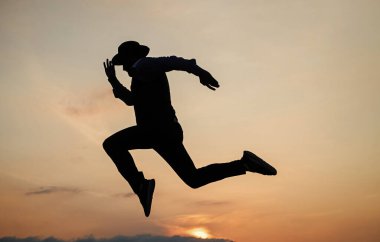 Yap ya da öl. Kişisel başarı hedefi. Adam silueti gökyüzü arka planında sıçrıyor. Kendine güvenen bir iş adamı. Günlük motivasyon. Hayatın ve doğanın tadını çıkarıyor. İş başarısı. özgürlük