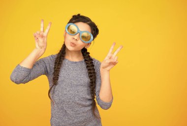 Parça jesti. Çocuk modası ve güzellik. Küçük kız havalı görünüyor. çocukluk mutluluğu. Güzel örülmüş uzun saçlar. Süslü örgüler ve örgüler. Parti eğlencesi. Gözlüklü komik genç kız.