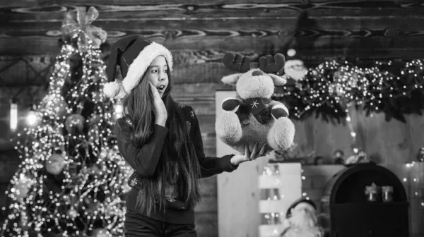 Sevimli geyik. Mutluluk ve neşe. Çocuk mutlu bir kız hediye ağacı bulur. Mutlu noeller. Mutlu çocukluk kavramı. Çocuk Noel Baba şapkası. Noel Baba hediye getirmiş. Mucize zamanı. Noel 'de tek istediğim — Stok fotoğraf