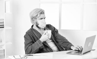 Verimli bir gün için tek ihtiyacın olan bu. Tamamen korunuyor. Koronavirüsten korumak için maske takıyor. Maskeli adam pipetle çay içer. Çok hijyenik. Merkez ofis. Uzaktan kumanda. Tıbbi maskeli bir işçi.