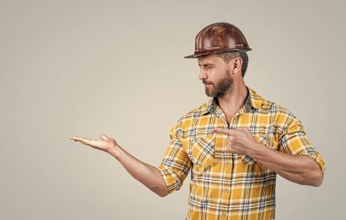 Her şey mükemmel olmalı. Adam mimar ürünü sunuyor. Adam işçi üniforması giyiyor. Miğferli müteahhit. Olgun adam kareli gömlek giyer. Profesyonel inşaatçı ya da tamirci. İnşaat mühendisi