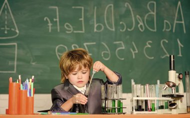 Bilgi toplama günü. Çocuk biyoloji kimyası okuyor. Mutlu bir çocukluk. Temel bilgi ilkokul eğitimi. Eğitim deneyi. Mikroskop ve test tüpleri sınıfındaki çocuk. Bilgi kavramı