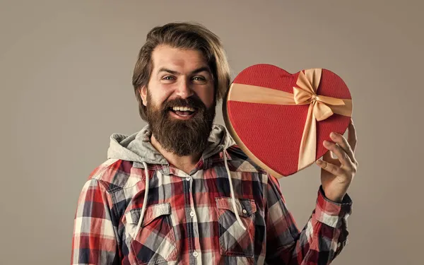 Hipster masculin barbu en chemise à carreaux tenir coeur boîte cadeau, être ma valentine — Photo