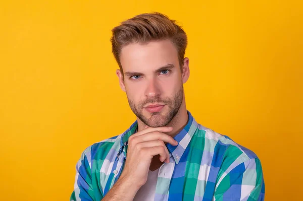 Portrét seriózního pohledného chlapa myslet s přemýšlivým obličejem žluté pozadí, myšlení — Stock fotografie
