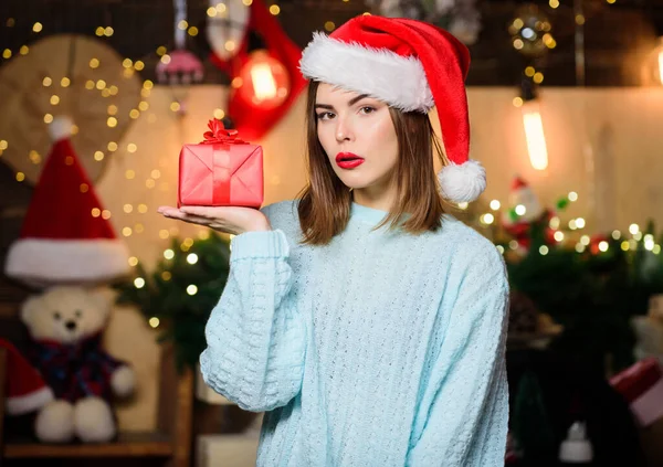 Flicka snygg makeup röda läppar hålla jul gåva. Mysig julstämning. Tro på mirakel. Kvinna jultomte hatt på julafton. Lady bedårande ansikte fira jul hemma. Öppna hennes gåva — Stockfoto