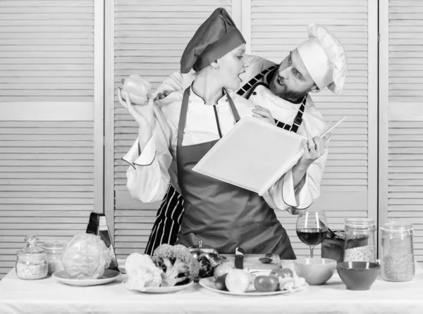 Improve cooking skill. Book recipes. Helpful culinary book. Woman chef and man cooking food together. Culinary family concept. Couple in love cooking healthy recipe. Amateur cook read book recipes — Stock Photo, Image