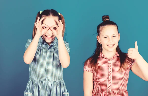 Jeugd is een leuke tijd. Gelukkige kleine meisjes die samen pret hebben. Kleine kinderen gesturing en het maken van grappige gezichten voor de lol. Schattige kinderen glimlachen terwijl het maken van wat plezier — Stockfoto