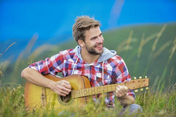 Wanderlied. Mann mit Gitarre auf dem Gipfel des Berges. Inspirierter Musiker. Sommer-Musikfestival im Freien. Die Stille der Berge und der Klang der Gitarrensaiten. Hipster-Musiker. Inspirierendes Umfeld — Stockfoto