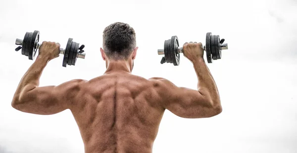 Hombre musculoso ejercitándose con mancuerna vista trasera. El dolor es temporal, el orgullo es para siempre. Deportista con espalda y brazos fuertes. Equipamiento deportivo. Deporte culturismo. Estilo de vida deportivo. Gimnasio de ejercicio Dumbbell —  Fotos de Stock