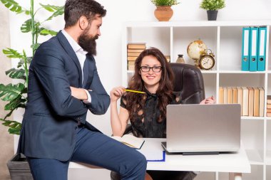 Takım elbiseli adam ofis masasında çalışırken çalışan mutlu profesyonel kadın.