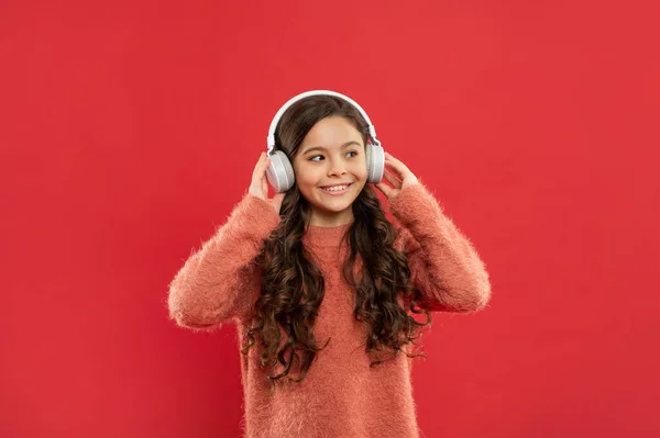 La vida moderna en la infancia. escuchando audiolibros. niño sonriente escuchar música en los auriculares. — Foto de Stock