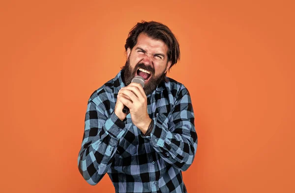 Chanteur barbu brutal homme rock chantant une chanson au microphone au karaoké, musique rock — Photo