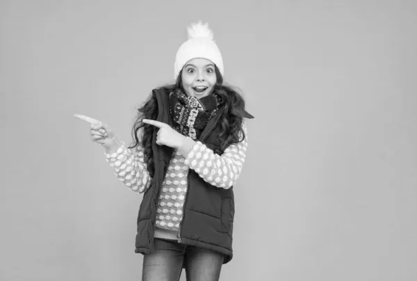 Venda de xmas lá. pronto para férias de Ano Novo. Sem hipotermia. menina alegre usar camadas de roupas. roupas quentes na temporada de inverno. previsão do tempo frio. Compras de moda infantil. dedo apontador — Fotografia de Stock