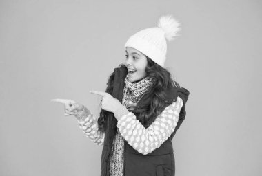 Giysi katmanları içinde neşeli bir kız, poz veren parmak. kopyalama alanı. Kış mevsiminde kalın giysiler. Soğuk hava tahmini. Çocuk moda alışverişi. Xmas zamanı. Yeni yıl tatiline hazırım. Hipotermi yok.
