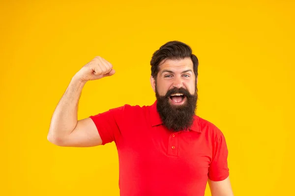 Glücklicher starker Kerl mit Bart und Frisur auf gelbem Hintergrund, Stärke — Stockfoto