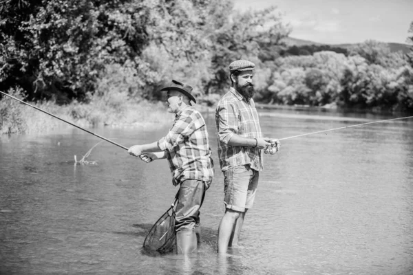 Buen equipo. pasatiempo y actividad deportiva. Cebo para truchas. padre e hijo pescando. dos pescador feliz con caña de pescar y red. amistad masculina. vinculación familiar. fin de semana de verano. hombres maduros pescador — Foto de Stock