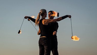 Hareket ve alev sanatı. Çift yanan poi mavi gökyüzü. Ateş sanatı festivali. Ateşli poi salınımı. Yangın gösterisi. Kültür ve spor. Eğlence ve eğlence. Tatil kutlaması. Sıcak dans