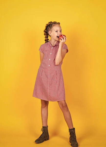Voorjaarsstemming. Gelukkig meisje met appels uit de tuin. Kind houdt vers fruit vast. Een kind dat rode appel eet. gezonde zomervoeding. vegetarisch dieet. vruchten bij de herfstoogst. Gezonde voeding in het najaar — Stockfoto