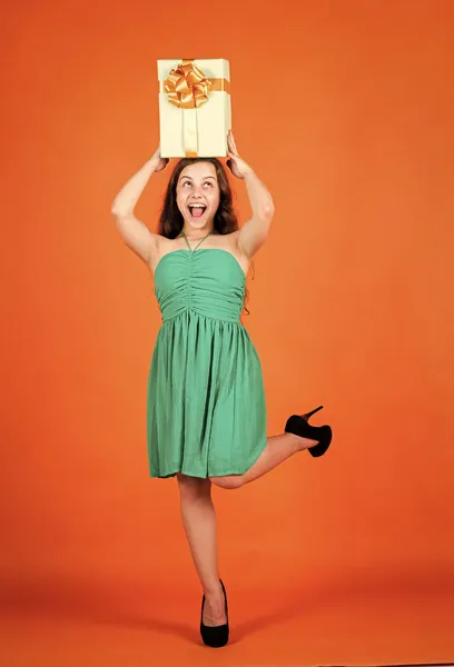 Boldog gyermek ajándék doboz narancssárga háttér, értékesítés — Stock Fotó