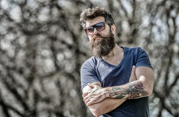 Homme barbu de lunettes de soleil fond nature. Homme barbu hipster brutal porter des lunettes de soleil de protection. Hipster confiant dans les lunettes de soleil sombres. Homme barbu porter des lunettes de soleil modernes à la mode. Filtre UV — Photo