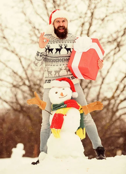 Before celebration. winter season activity. Merry christmas. bearded man build snowman. winter holiday. warm sweater in cold weather. santa man give present outdoor. happy hipster ready for xmas — Stock Photo, Image