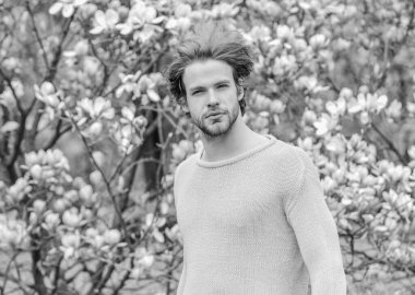 Bahar güzeli. Botanik bahçesi. Erkek çiçek arka planı. Tazelik ve uyanış. Bahar ilham. Baharın neşesi. Modern hipster çiçekleri sever. İlkbahar konsepti. Adam çiçek parkında rahatlıyor.