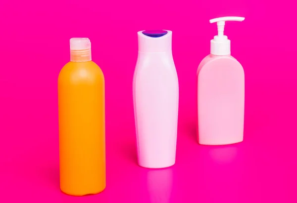 Our packaging solutions. Toiletry bottles pink background. Refillable bottles in row — Stock Photo, Image