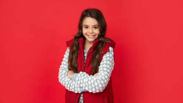 Menina adolescente alegre com cabelo encaracolado em roupas de inverno no fundo vermelho, rosto — Fotografia de Stock