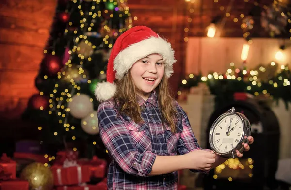 Sto aspettando. Bambina di Babbo Natale. Bambina col cappello rosso. Aspetta Babbo Natale. E 'Natale. Babbo Natale. Bambino elfo con orologio. Albero di Natale. Felice anno nuovo. Babbo Natale per favore vieni — Foto Stock