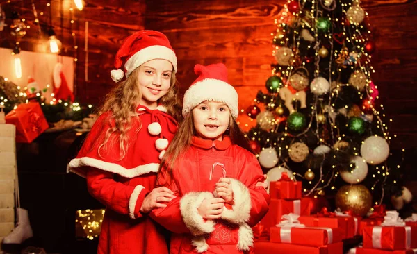 Noel eğlencesi. Mutlu aile yeni yılı kutluyor. Yılbaşı zamanı. Kış tatillerini severim. Kırmızı Noel Baba şapkalı küçük kızlar. Noel hediyesini bekle. Kış alışverişi. Küçük kız kardeşler hediye ister. — Stok fotoğraf
