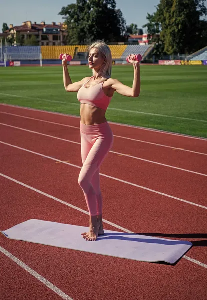 Sexig kvinna träning med skivstång på arenan utomhus, tyngdlyftning — Stockfoto