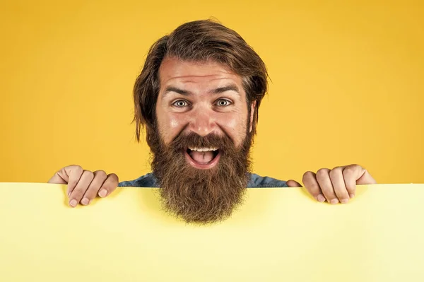 Continua a sorrir e continua. Procurado. papel vazio para sua informação. conceito barbeiro. hipster feliz com barba em folha de papel. lugar vazio para espaço de cópia. Preciso de ajuda. homem barbudo segurando placate — Fotografia de Stock