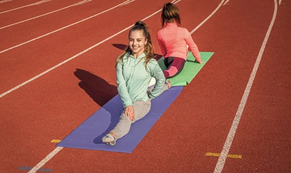 Ginastas se preparam para a competição. atletas se aquecem no ginásio do estádio. flexibilidade dividida. crianças treinando na aula de física da escola. meninas adolescentes que se alongam antes do treinamento. Tudo é possível — Fotografia de Stock