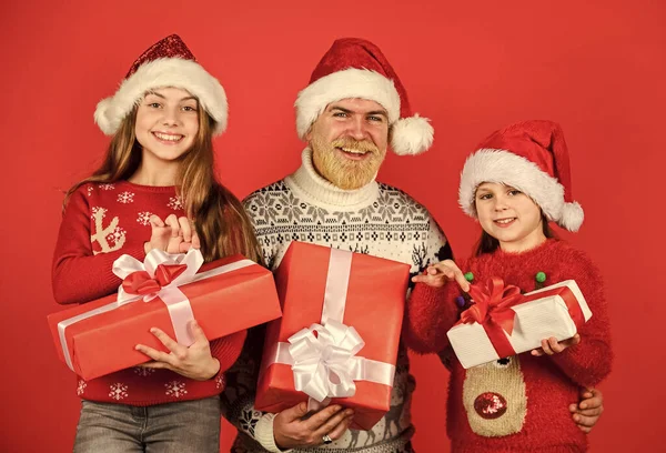 Χριστουγεννιάτικα δώρα. Τα μικρά κορίτσια ανταλλάσσουν δώρα με τον πατέρα. Ο μπαμπάς αγαπάει τις κόρες. Άγιος Βασίλης με παιδί. πλεκτή μόδα για το χειμώνα. Νέα χρονιά για ψώνια. Ώρα για δώρα. Ευτυχισμένη οικογένεια γιορτάζουν Χριστούγεννα — Φωτογραφία Αρχείου