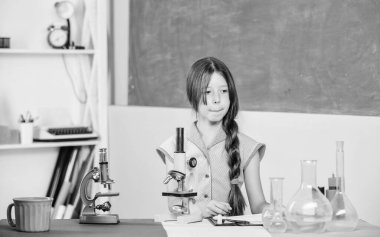 Bilim benim hayatım. Okul laboratuarı. Modern teknoloji. Okula dönüyorum. Biyoloji eğitimi. Mikroskopla fen dersi. Laboratuvar matarası olan küçük bir kız. kız test tüpüyle kimya okuyor.