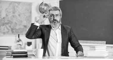 Okula dönelim. Bilgi toplama günü. Erkek okul öğretmeni sınıfta oturur. Yakışıklı, olgun, akıllı eğitimci. Sunum için tezin uygunluğundan emin olun. Evrak işleri belgesel dosyaları. Okul ödevi