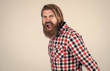 Kaba sakallı, kareli gömlek giyen, sakallı, bıyıklı, sinirli, vahşi bir adam.