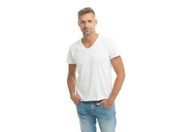 Beyaz tişörtlü, ciddi yakışıklı adam elini pantolonunun cebine sokar.