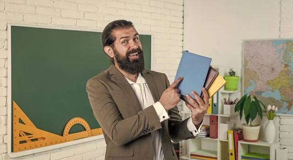 Professor feliz com livro e livros prontos para a lição, escola — Fotografia de Stock