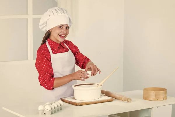 Sorrindo menina adolescente em chef uniforme cozinhar e assar, comida — Fotografia de Stock