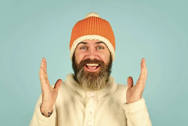 Ik kan er niet in geloven. gebreide muts beschermen tegen kou. Een man met een baard draagt een winterhoed. mode kleding voor koud weer. volwassen hipster blauwe achtergrond. Mannenmode. najaarsweersvoorspelling — Stockfoto