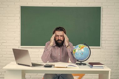 Çok fazla iş var, uykucu adam dizüstü bilgisayarın önünde oturuyor, üniversitede yoğun bir program var.