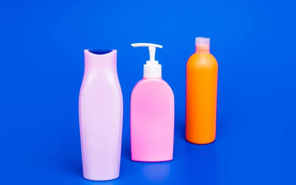 Toaletowe i kosmetyczne pojemniki plastikowe do płynnego prysznica i produktów kąpielowych pakowane w rzędzie, butelki — Zdjęcie stockowe