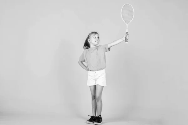 Bonito criança jogar tênis ou badminton. modo de vida ativo. cheia de energia. bela menina adolescente com raquete de tênis. estilo de moda esporte infantil. fitness e saúde. infância feliz. O desporto é a nossa vida — Fotografia de Stock