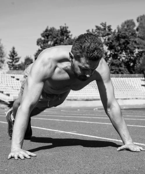 Musculoso hombre de pie en la tabla haciendo empujar hacia arriba en el entrenamiento deportivo, poder —  Fotos de Stock