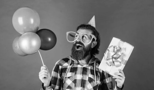 Man hipster med fashionabla preparerat hår och skägg hålla fest ballonger och låda, födelsedag — Stockfoto