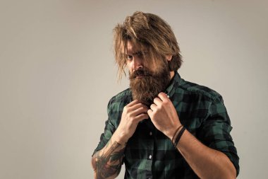 Erkek berber bakımı. Gömlekli kendine güvenen adam. Sakallı adam. Berber salonu konsepti. Erkek güzelliği. Sakallı, olgun bir hippi. Bıyıklı, vahşi, beyaz bir hippi. Kişisel bakım