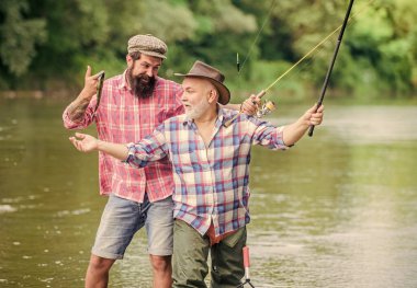 Atom hobisi. Uçan Balık Zamanı. Hobi. Elinde olta ve ağla iki mutlu balıkçı. Büyük balık avı. Arkadaşlık. Turizm avcılığı. Baba oğul balık tutuyor. Gölün kıyısında kamp yapmak
